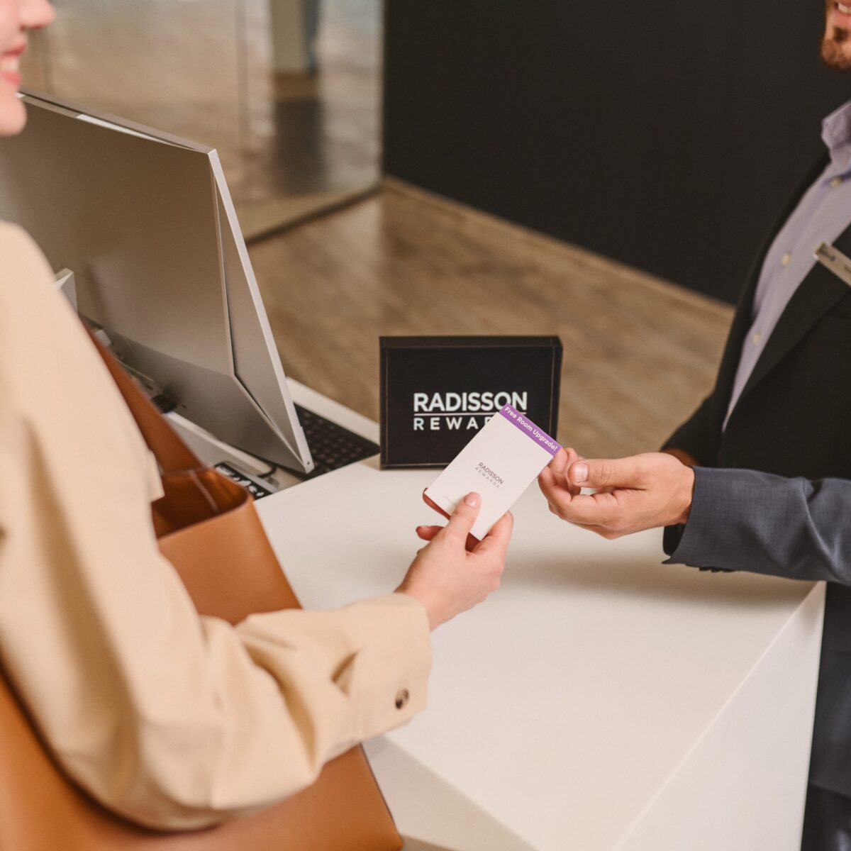 Guest receiving a free room upgrade because of Radisson Rewards from a receptionist